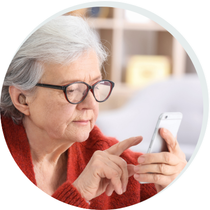 Mature woman with hearing aid using smartphone indoors