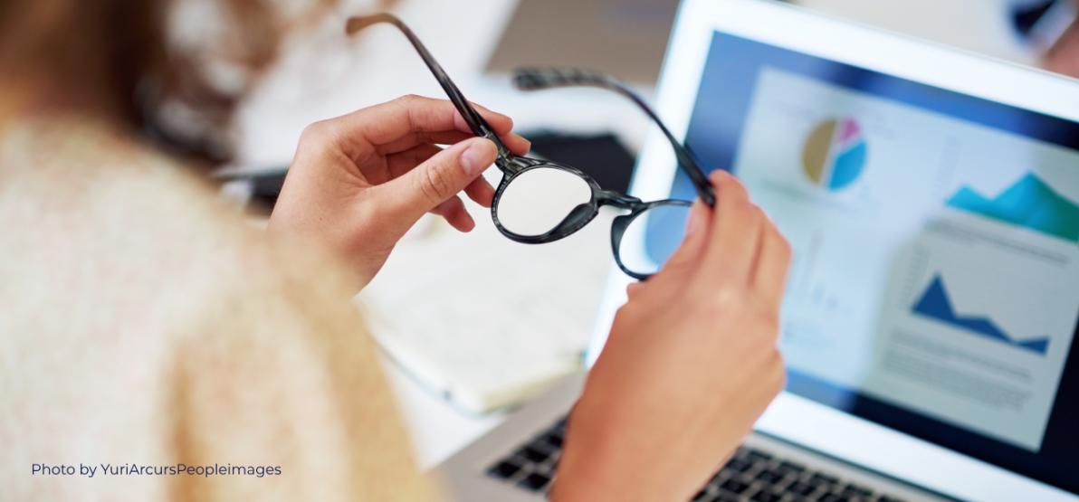 A user wearing glasses using a laptop