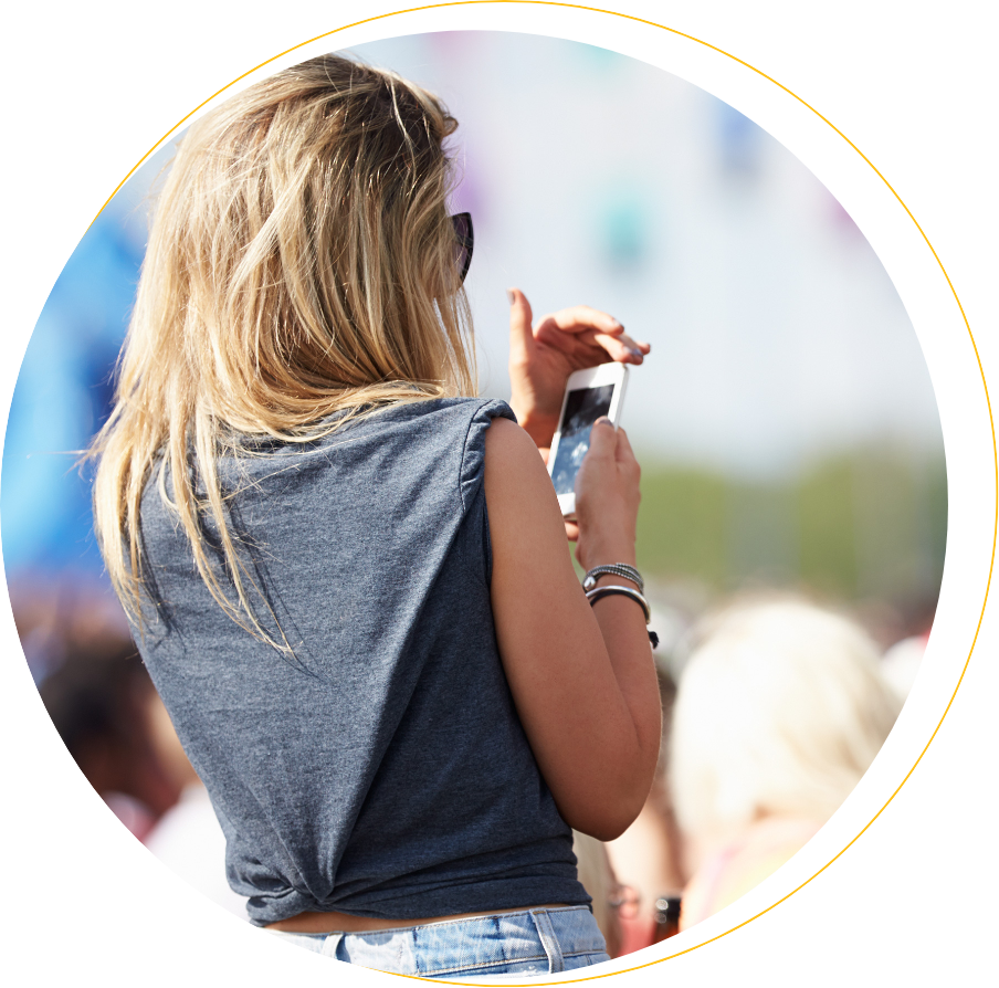 Young woman outdoors using mobile phone with difficulty because of sun